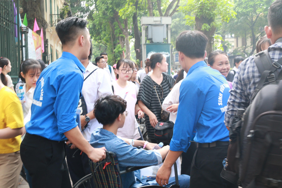 Khi đến điểm thi, Tân luôn nhận được sự giúp đỡ tận tình của các sinh viên tình nguyện, đưa em vào tận phòng thi cũng như khi rời điểm thi. (Ảnh: Nguyễn Hoàng/Vietnam+)