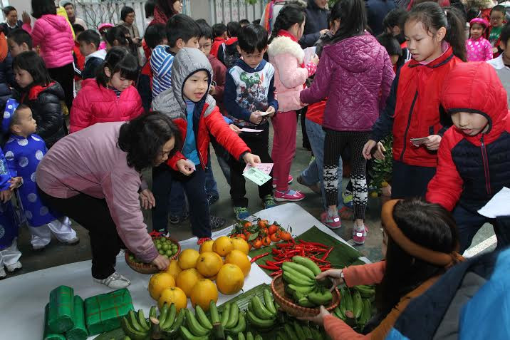 Học sinh và cả phụ huynh đều say sưa mua bán. (Ảnh: CTV/Vietnam+)