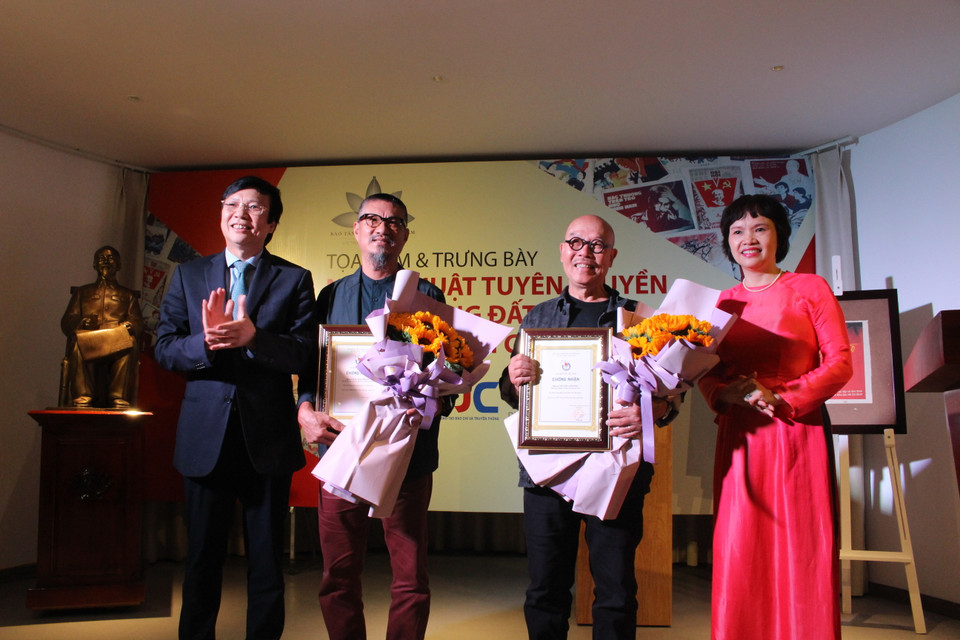 (Từ trái sang) Cũng tại triển lãm này, ông Hồ Quang Lợi, Phó Chủ tịch trường trực Hội Nhà báo Việt Nam trao giấy chứng nhận cho hai họa sỹ Đào Hải Phong và Thành Chương vì đã đóng góp hai bức tranh vẽ trên giấy báo cho Bảo tàng. (Ảnh: Minh Anh/Vietnam+)