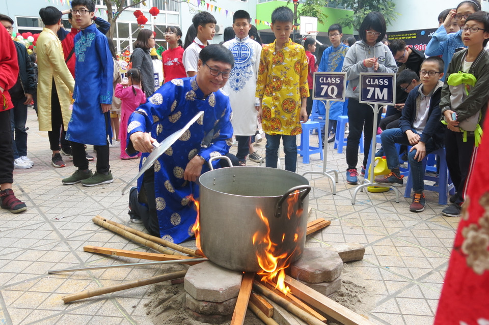 Và cẩn thận kiểm tra nồi bánh được luộc ngay tại sân trường. (Ảnh: PV/Vietnam+)