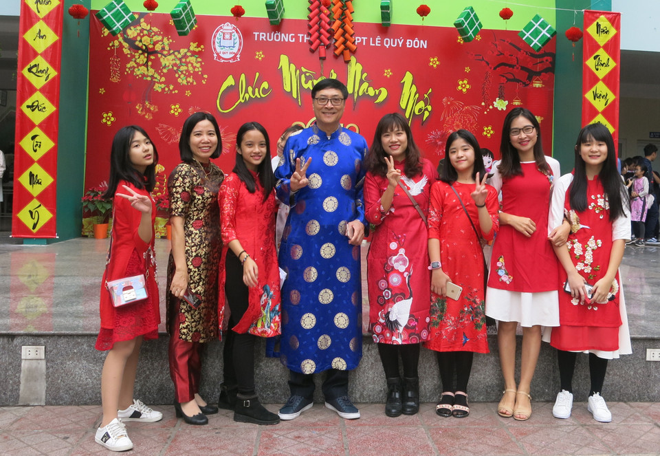 Trong chương trình Chúc mừng năm mới xuân Kỷ Hợi 2019, nhiều học sinh Trường Trung học cơ sở và Trung học phổ thông Lê Quý Đôn (Hà Nội) đã rất thích thú khi thầy Hiệu trưởng Nguyễn Quốc Bình mặc áo dài, tạo dáng "xì tin" cùng trò. (Ảnh: PV/Vietnam+)