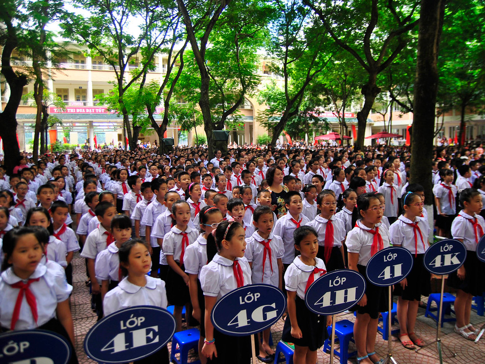 Trong khi các bé lớp một mải nói chuyện thì các anh chị lớp 4 tỏ ra rất chững chạc, chăm chú theo dõi buổi lễ. (Ảnh: Võ Phương/Vietnam+)