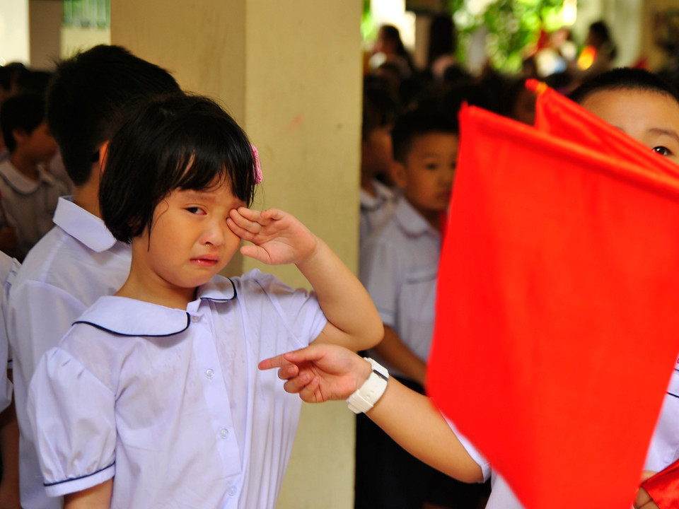 Không ít bé vẫn còn bỡ ngỡ với môi trường mới, mắt ướt nhạt nhòa trong ngày khai giảng năm học mới. (Ảnh: Võ Phương/Vietnam+)