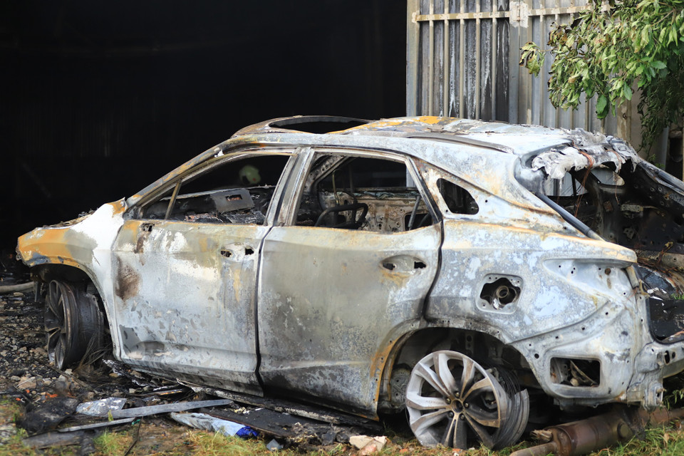 Một ôtô bị cháy rụi từ đám cháy lớn. (Ảnh: PV/Vietnam+)