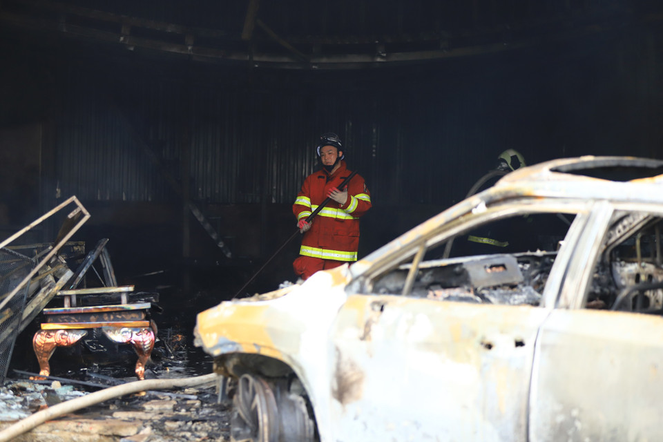 Nhiều kho xưởng kế bên cũng đã di chuyển đồ đạc ra ngoài để tránh thiệt hại. (Ảnh: PV/Vietnam+)