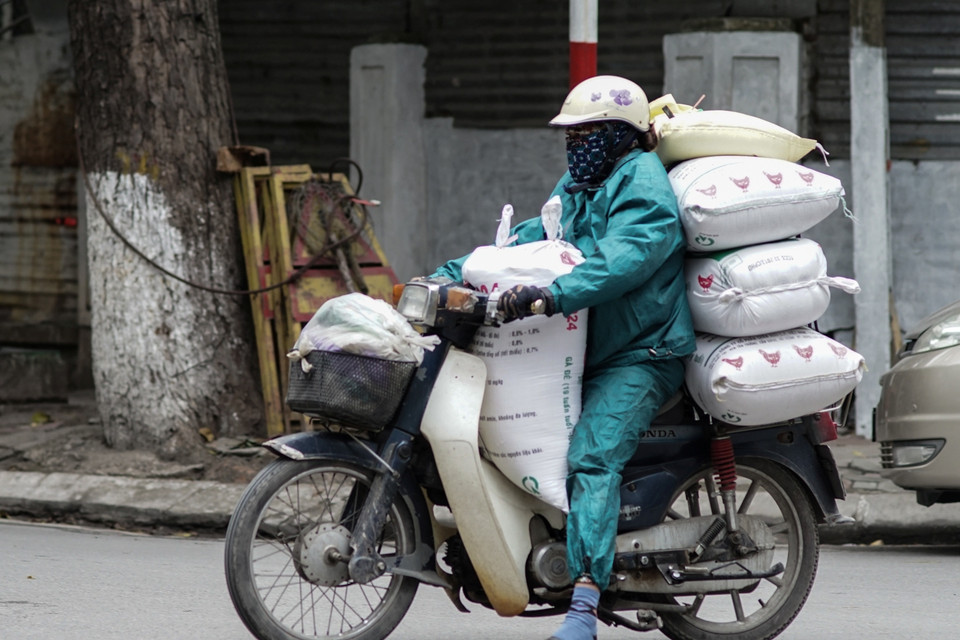 Người lao động vất vả mưu sinh trong thời tiết giá buốt. (Ảnh: Hoàng Long/Vietnam+)