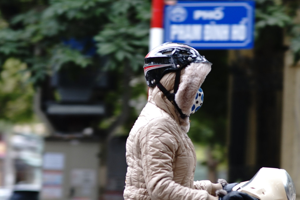 Những chiếc áo khoác có mũ liền phát huy tác dụng trong ngày lạnh giá. (Ảnh: Hoàng Long/Vietnam+)