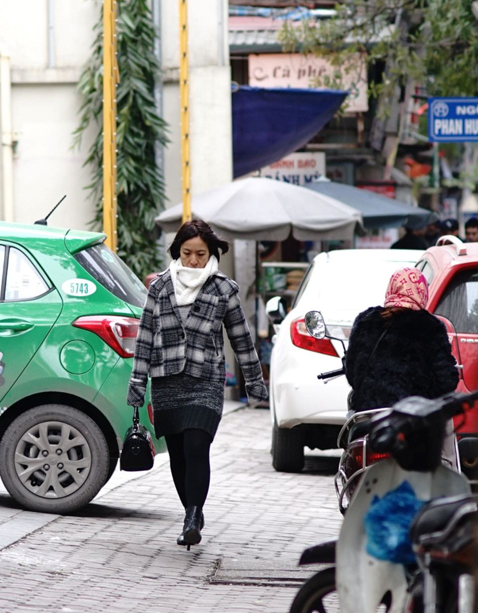 Người đi bộ cũng cố rảo bước nhanh hơn. (Ảnh: Hoàng Long/Vietnam+)