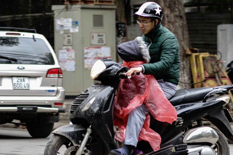 Tư thế ‘đặc biệt’ để tránh gió cho em bé. (Ảnh: Hoàng Long/Vietnam+)