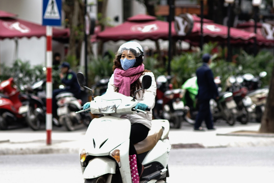 Người đi đường chỉ để hở đôi mắt khi đi ra đường. (Ảnh: Hoàng Long/Vietnam+)