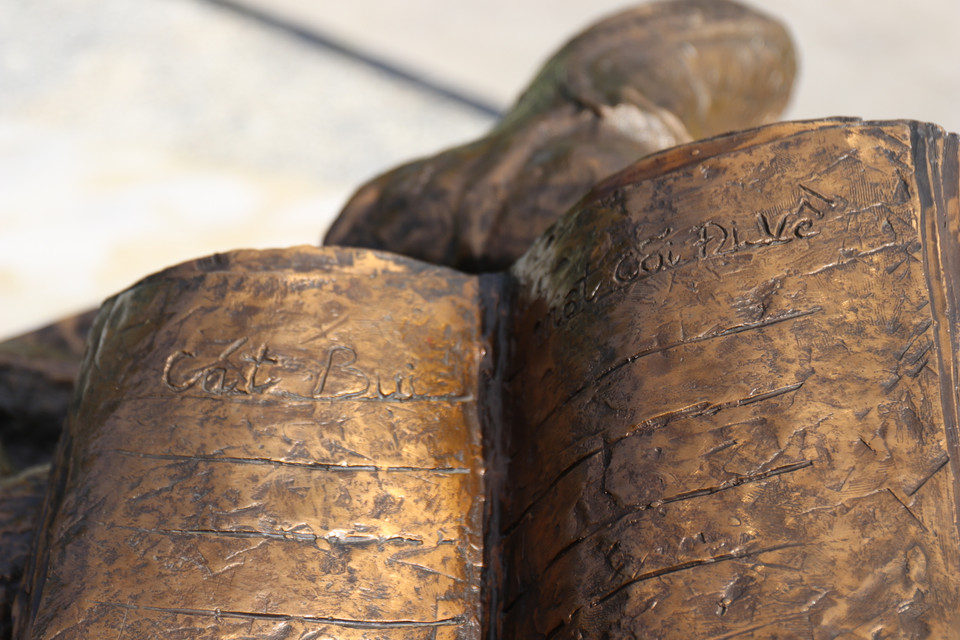 Trên tượng khắc họa 2 trang viết, ghi “Cát bụi” và “Một cõi đi về.” Hai ca khúc đều nói về sự đi và ở trên cõi tạm, một sự trăn trở thường trực trong Trịnh Công Sơn. (Ảnh: Minh Anh/Vietnam+)