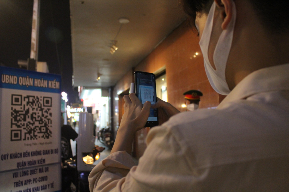 Người dân nhìn chung đều tuân thủ thực hiện các công tác quét mã, xịt khử khuẩn và đeo khẩu trang liên tục. (Ảnh: Minh Anh/Vietnam+)