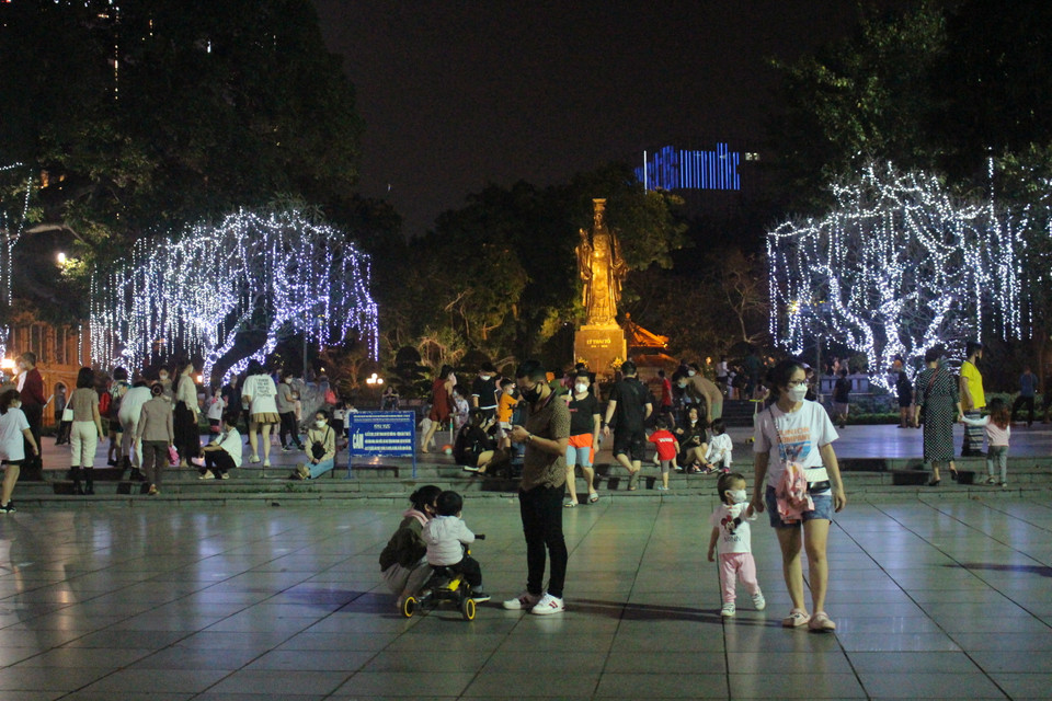 Các hoạt động tại khu vực tượng đài Lý Thái Tổ được treo đèn sáng và đẹp, là điểm dừng chân của nhiều gia đình khi ghé khu vực đi bộ quanh Hồ Gươm. (Ảnh: Minh Anh/Vietnam+)