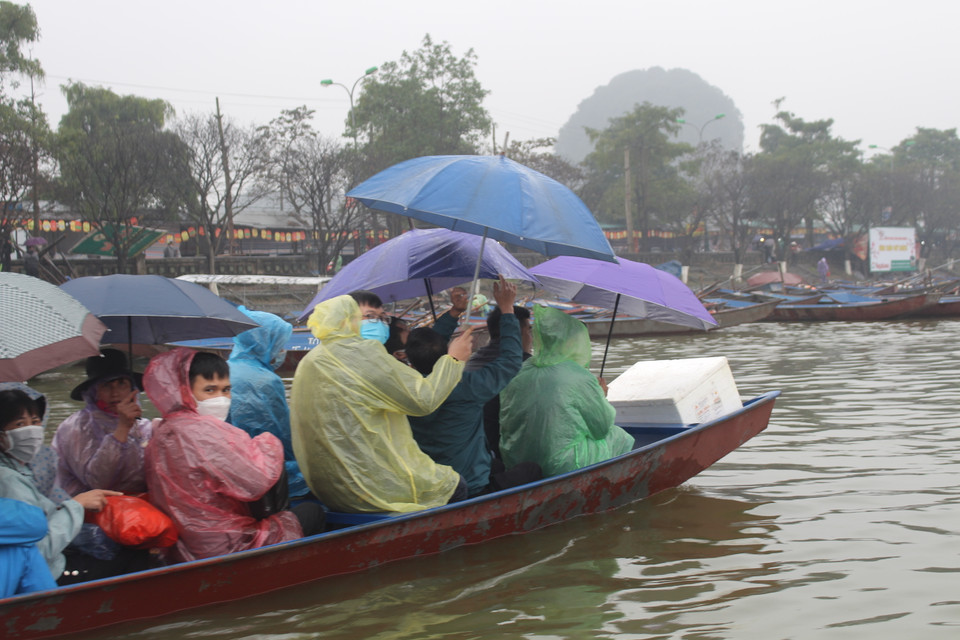 Tuy nhiên, có nhiều khách khi đi theo đoàn lớn đã chủ quan, bỏ khẩu trang khi ngồi trên đò hoặc đi cùng nhau. Một số khác cũng túm tụm, quay vào nhau để cùng ăn uống. (Ảnh: Minh Anh/Vietnam+)