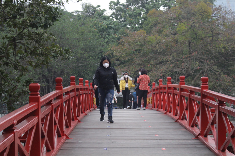 Biết được thói quen nhiều người dân bỏ khẩu trang khi chụp ảnh trên cầu Thê Húc, đại diện ban quản lý đền cũng đã phân công nhân viên để nhắc nhở liên tục. (Ảnh: Minh Anh/Vietnam+)