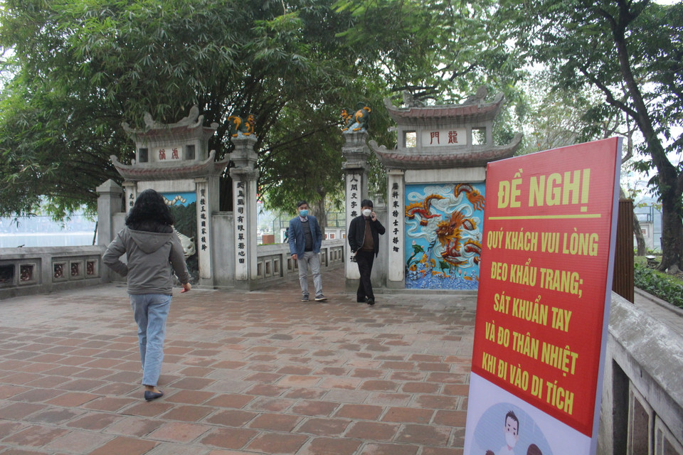 Đền Ngọc Sơn trong sáng ngày mở lại cũng đặt khuyến cáo và nhắc nhở ở nhiều vị trí. (Ảnh: Minh Anh/Vietnam+)