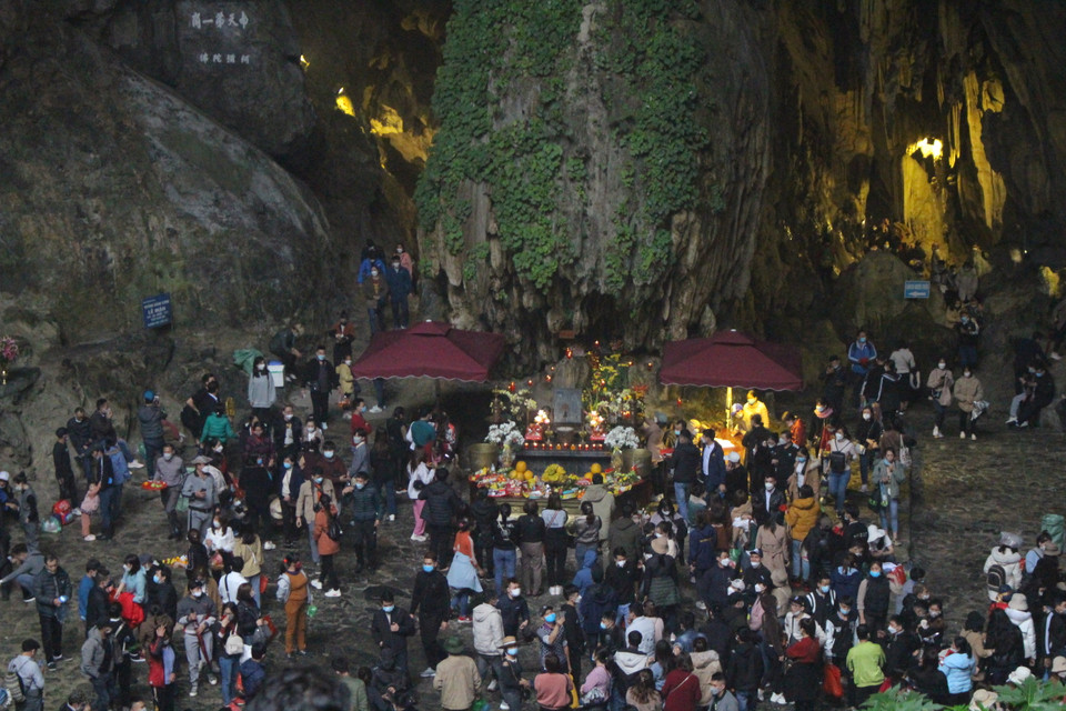 Tuy lượng khách có phần ít hơn so với những năm trước khi có dịch, người dân tập trung cầu khấn trong động vẫn khá lớn. (Ảnh: Minh Anh/Vietnam+)