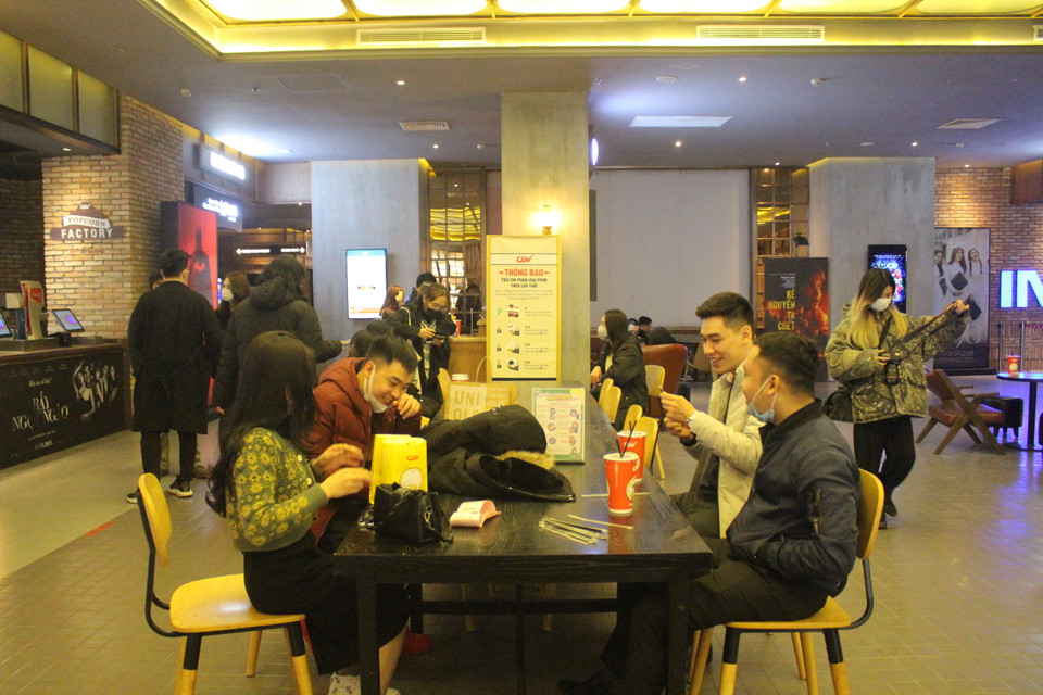 Song theo ghi nhận của phóng viên, bên cạnh nhiều khán giả thận trọng thì có nhiều khách hàng vẫn bỏ khẩu trang khá lâu để ăn bỏng ngô và uống nước. (Ảnh: Minh Anh/Vietnam+)