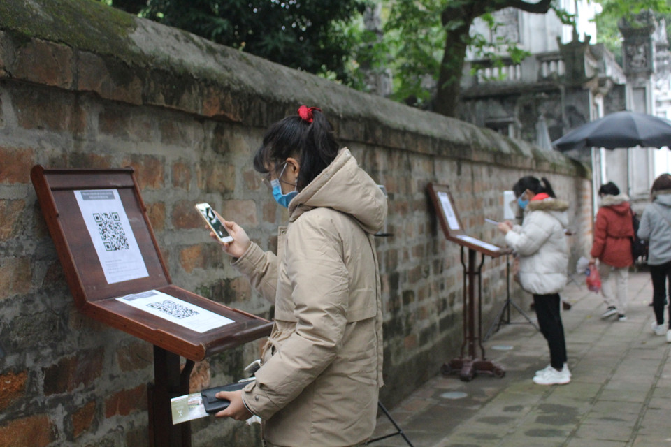 Trong ngày đầu mở lại các di tích (15/2), các công tác chống dịch đều được đảm bảo. Tại Văn Miếu-Quốc Tử Giám, mã QR, máy xịt sát khuẩn và khu vực bán vé đều được bố trí hoặc có người hướng dẫn, đảm bảo khách đứng giãn cách. (Ảnh: Minh Anh/Vietnam+)