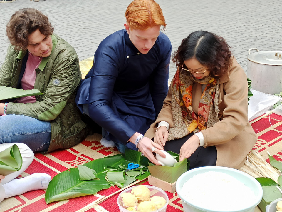 Melchior Reimers (áo xanh) đến từ Đại học WHU-Otto Beisheim School Management (Đức) chỉ vừa đến Việt Nam được hai tuần và đặc biệt thích thú khi biết được tham gia chuẩn bị đón Tết Nguyên đán của người Việt. Em cho biết rất háo hức chờ đợi được nếm thử món bánh chưng vì chưa từng được ăn trước đó. (Ảnh: PV/Vietnam+).