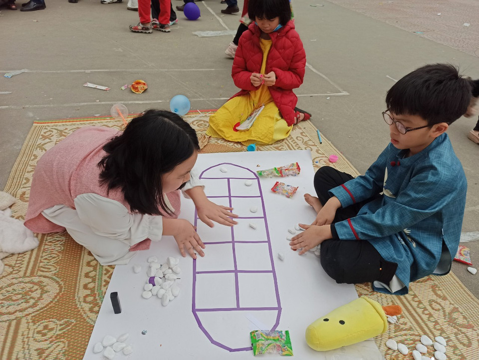 Học sinh trải nghiệm trò chơi dân gian ô ăn quan. (Ảnh: PV/Vietnam+)