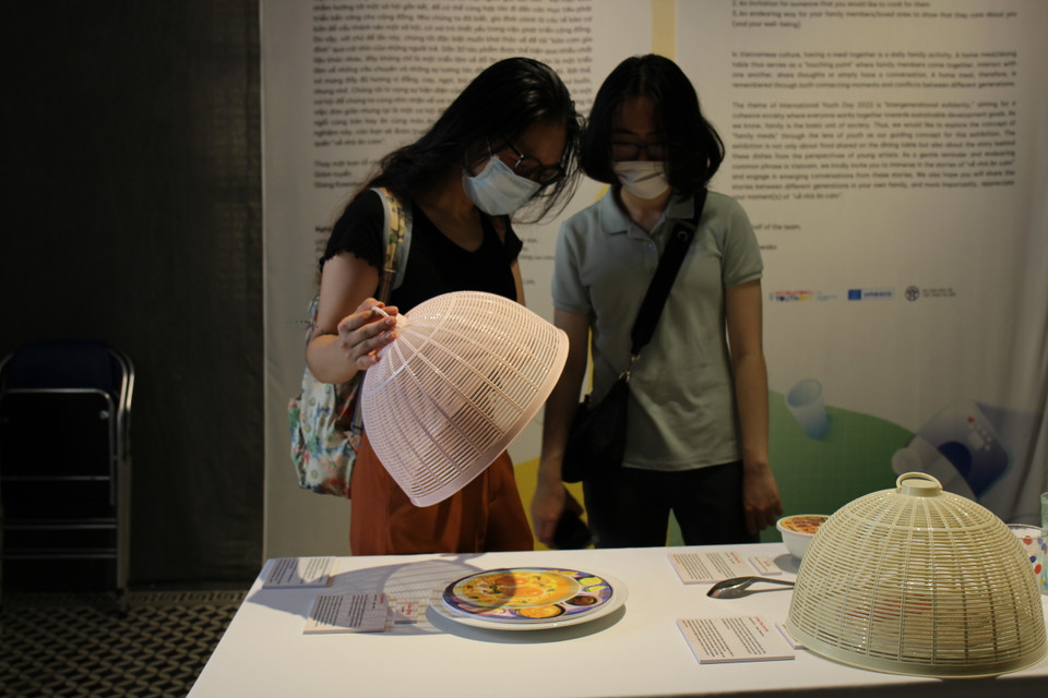 ''Bữa cơm nhà là điểm chạm của các thành viên trong gia đình. Phòng bếp hay bàn ăn trở thành nơi những cuộc hội thoại, chia sẻ, tâm sự, tương tác của mọi người diễn ra hàng ngày'' - người giám tuyển của triển lãm viết trong lời giới thiệu. (Ảnh: Minh Anh/Vietnam+) 