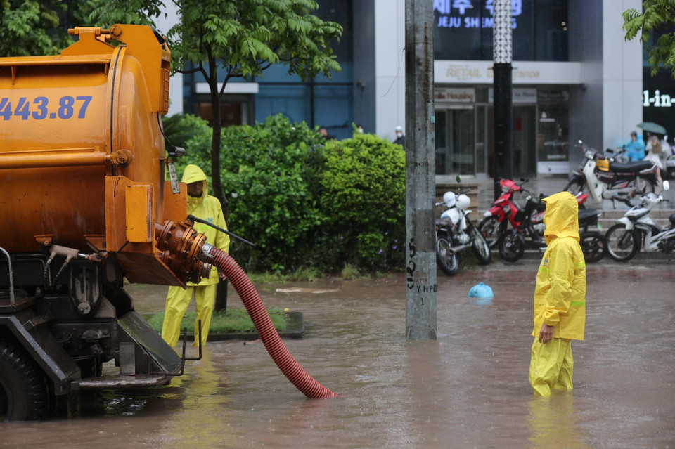 Giữa giờ sáng, đơn vị thoát nước đã có mặt để xử lý vùng ngập. (Ảnh: Minh Sơn/Vietnam+)