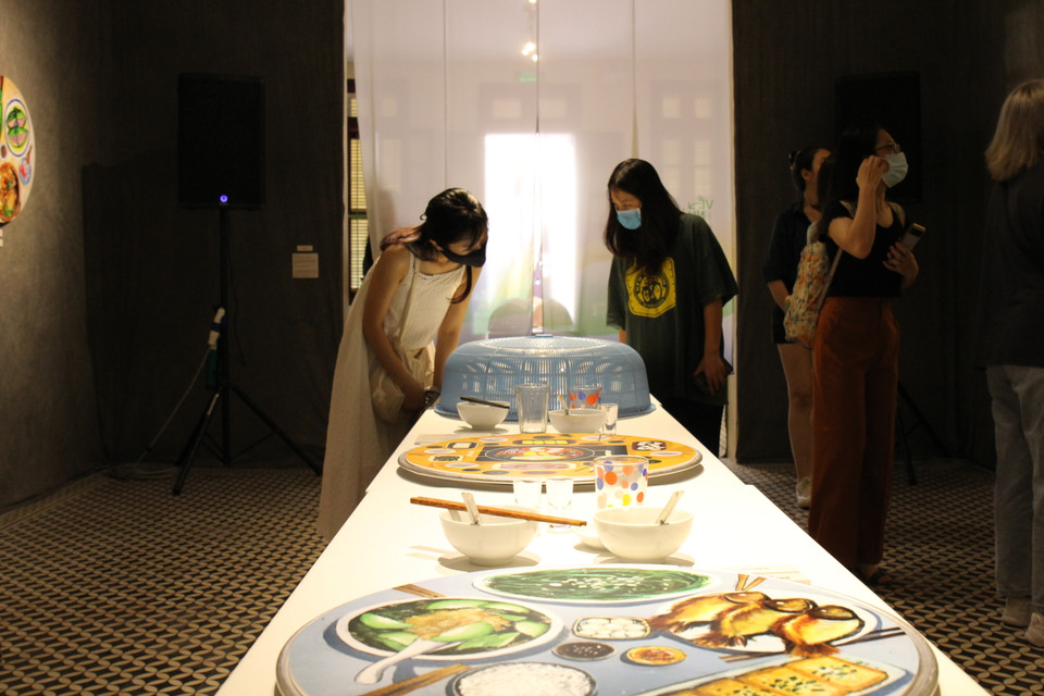 Triển lãm mang đến những ''mâm cơm'' từ đầy đặn, cầu kỳ đến đơn giản nhất. Tất cả đều là hình ''dẹt'' được in ra, đặt trên một chiếc mâm thật. (Minh Anh/Vietnam+)