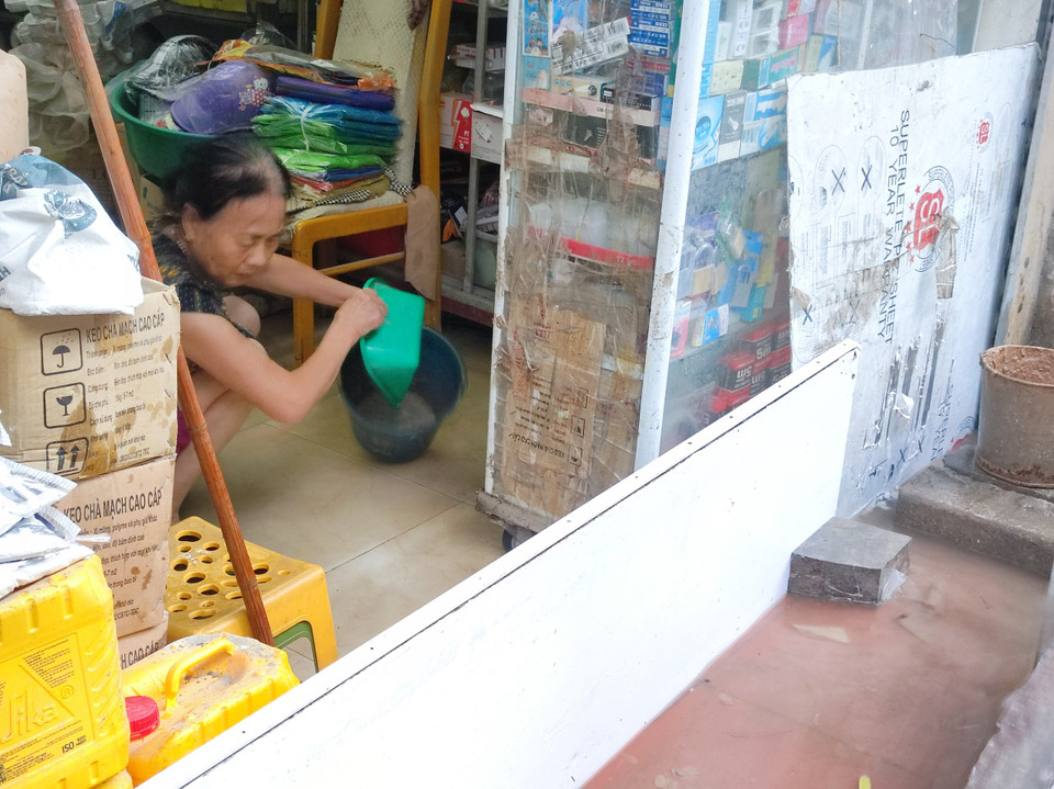 Người dân ở khu vực Triều Khúc che chắn để ngăn nước mưa tràn vào nhà. (Ảnh: Hoài Nam/Vietnam+)