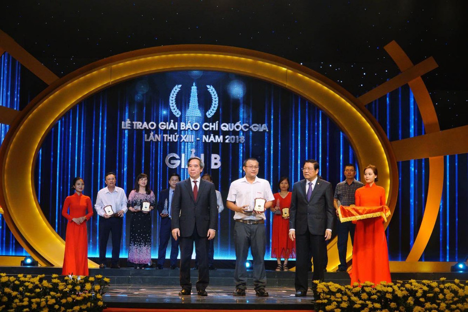Phóng viên Trần Sơn Bách - đại diện nhóm tác giả loạt bài 'Họ hy sinh cho nước bạn hồi sinh' nhận giải B. (Ảnh: Minh Hiếu/Vietnam+)