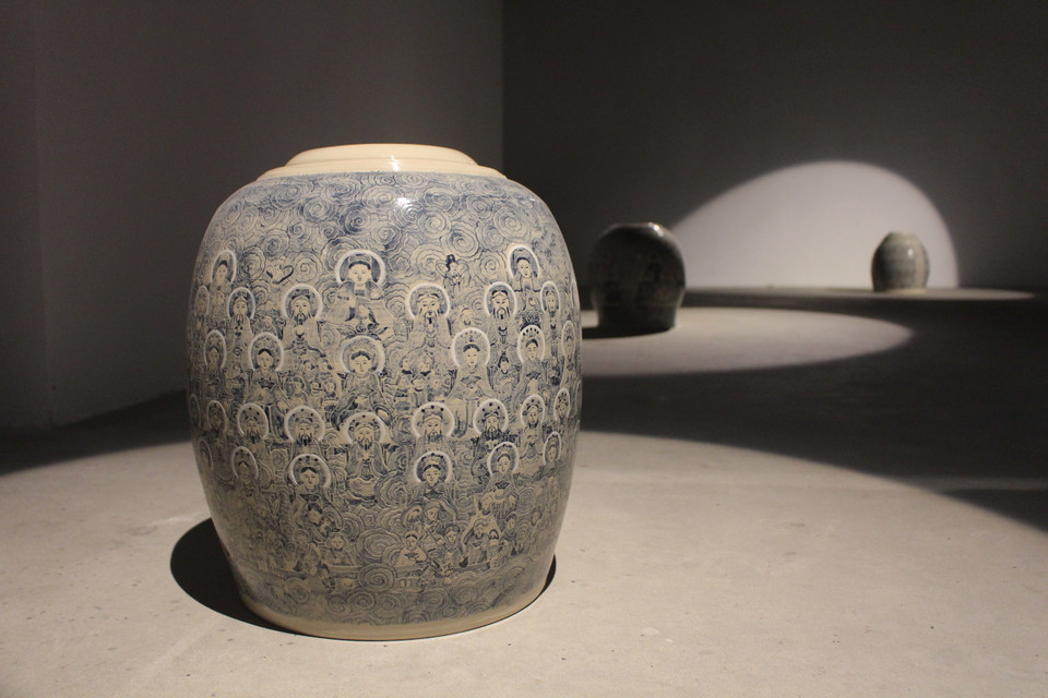 Mang đến triển lãm 32 tác phẩm gốm, Trịnh Vũ Hiếu gửi gắm trên đó những hình ảnh và chủ đề quen thuộc của tranh Hàng Trống, đặc biệt là tranh thờ. Dễ thấy trên những bình gốm thủ công của tác giả này hình ảnh Tứ phủ công đồng, Ngũ vị tôn quan, Đức Thánh Trần… trong tín ngưỡng thờ Mẫu được vẽ, khắc tỉ mỉ, cẩn thận. (Ảnh: Minh Anh/Vietnam+)