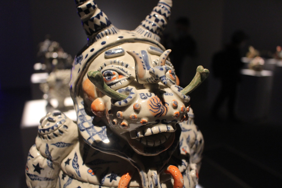 Với ý tưởng ấy, những thứ 'va' vào nhau không chỉ có duy nhất gốm, mà còn là gốm với những cảm hứng rất đỗi tự nhiên cho truyền thống. Những chất liệu ấy chính là tò he thể hiện qua các tác phẩm của Bùi Quốc Khánh (trong hình) và tranh Hàng Trống trên gốm của Trịnh Vũ Hiếu. (Ảnh: Minh Anh/Vietnam+)