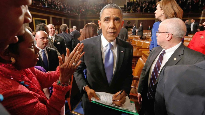 Tổng thống Obama ký vào bản copy diễn văn Thông điệp Liên bang cho một khán giả khi rời khỏi phòng hội nghị (Ảnh: Getty Images)