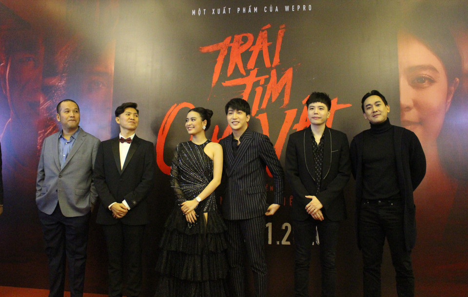 'Trái tim quái vật' là tác phẩm phim dài đầu tay của đạo diễn Tạ Nguyên Hiệp, dựa trên những vụ án mạng có thật ở chung cư tại Việt Nam. Một trong đó có vụ án ở chung cư G4, khu đô thị Yên Hòa vào năm 2010. Đây là bộ phim Việt Nam thứ hai trong năm 2020 theo đuổi thể loại trinh thám, hình sự bên cạnh 'Bằng chứng vô hình' ra mắt dịp Tết. Phim có sự góp mặt của những gương mặt nổi tiếng trong giới showbiz, dù không phải những “ông vua/bà hoàng phòng vé,” gồm nữ ca sỹ, diễn viên Hoàng Thùy Linh, ca sỹ trẻ Trịnh Thăng Bình, diễn viên Hứa Vĩ Văn và B Trần. Từ trái sang: Nhà sản xuất Quang Huy, đạo diễn Tạ Nguyên Hiệp, dàn diễn viên Hoàng Thùy Linh, B Trần, Trịnh Thăng Bình, Hứa Vĩ Văn. (Ảnh: Minh Anh/Vietnam+)