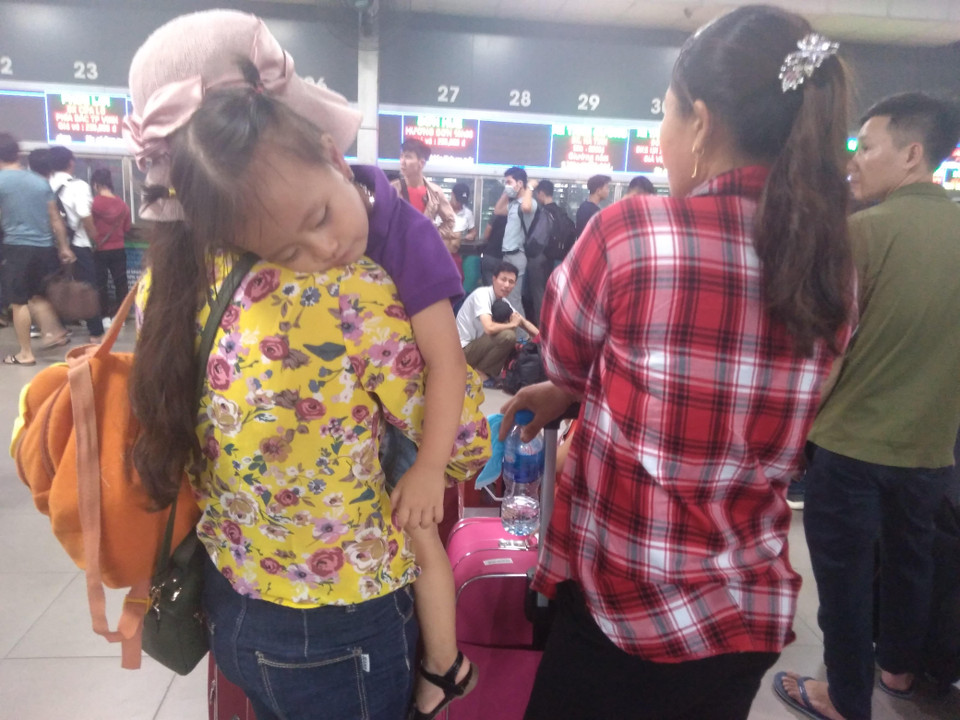 Những em nhỏ ngủ thiếp trên vai người lớn.(Ảnh: Anh Thùy/Vietnam+)