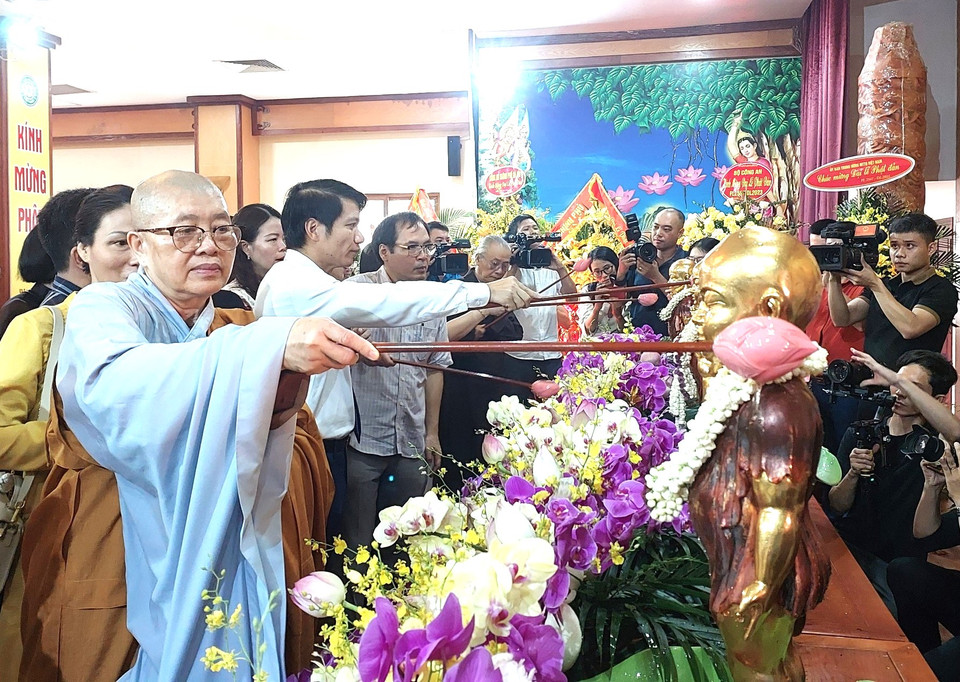 Tắm Phật là nghi lễ không thể thiếu trong Đại lễ Phật đản. Tăng ni, Phật tử tự tay múc nước thanh khiết vào bát/gáo hình hoa sen. Khi tắm Phật, gáo nước thứ nhất sẽ xối từ vai bên trái tôn tượng Đức Phật với ý nghĩa nguyện bỏ điều ác. Gáo nước thứ hai xối cánh tay bên phải của Đức Phật với ý nghĩa nguyện làm những điều lành. Gáo nước thứ ba sẽ xối lên đôi bàn chân của Đức Phật cầu nguyện điều lành cho tất cả mọi người. (Ảnh: Minh Thu/Vietnam+)