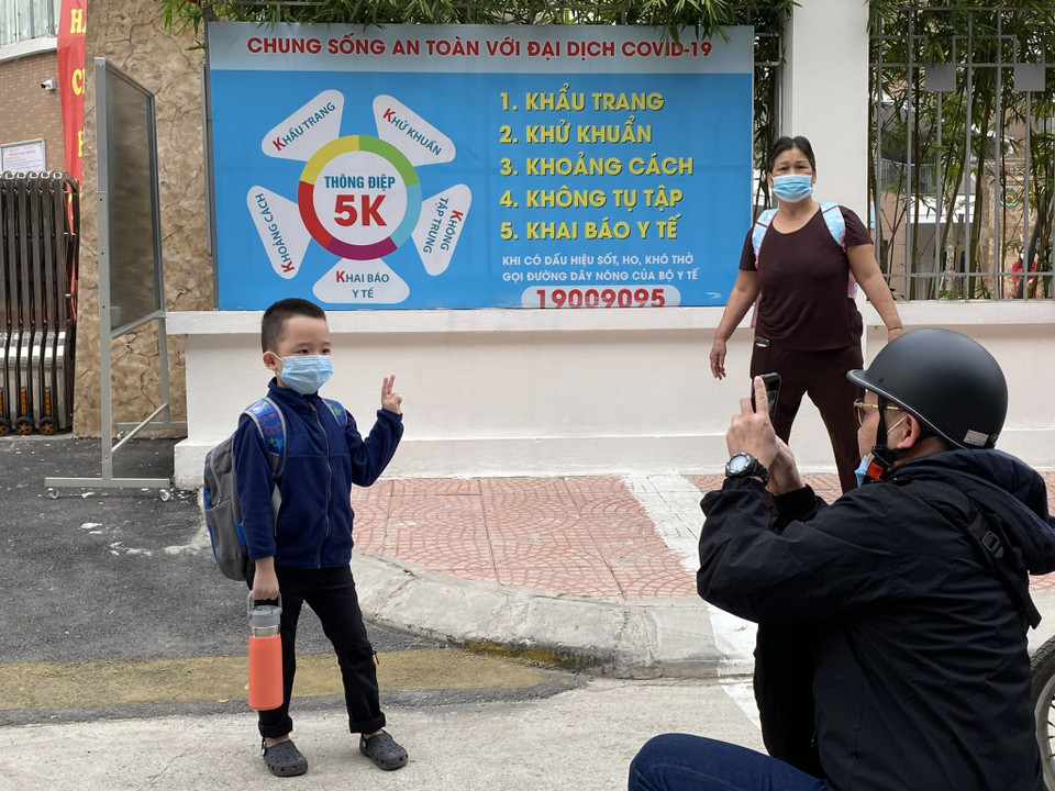 Việc được đi học trực tiếp, được tiếp xúc với bạn bè, thầy cô khiến cha mẹ và học sinh đều hào hứng. Hình ảnh ghi nhận tại trường Tiểu học Hoàng Mai, vị phụ huynh này ghi lại khoảnh khắc con trai lần đầu tiên bước chân tới trường tiểu học. (Ảnh: PV/Vietnam+)