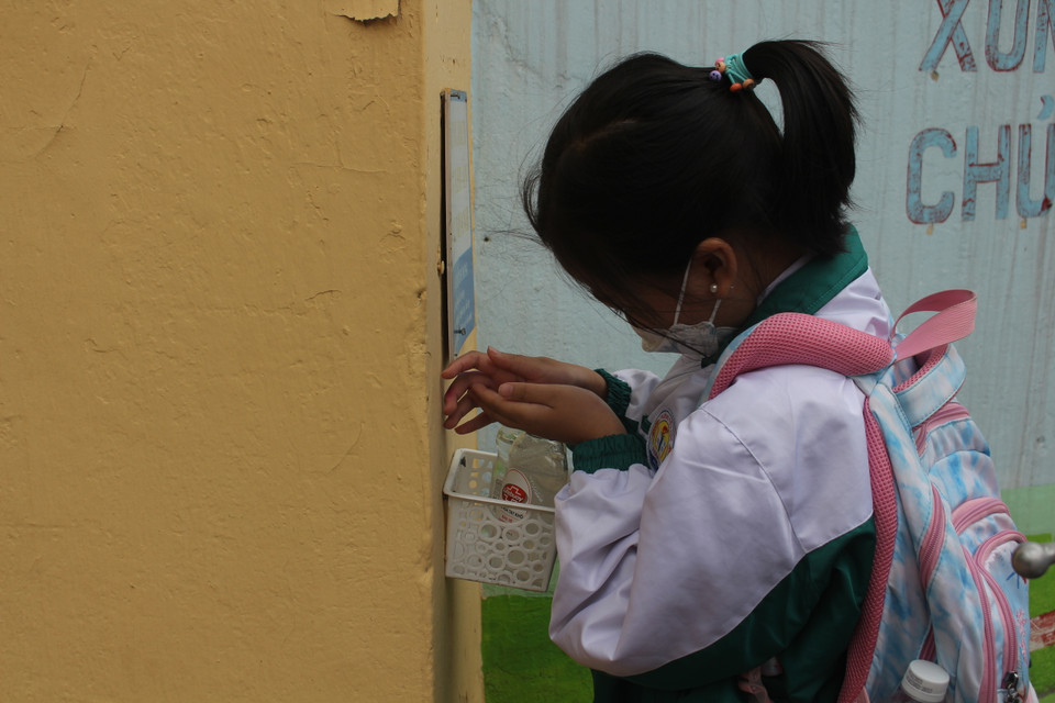 Ghi nhận tại trường tiểu học Phạm Tu (Thanh Trì) học sinh chủ động xịt khuẩn tại cổng trường. Khi có đông người, các em được điều phối hướng dẫn vào lớp xịt khuẩn, loa phát thanh cũng liên tục nhắc nhở các con nhanh chân vào lớp. (Ảnh: Minh Anh/Vietnam+)