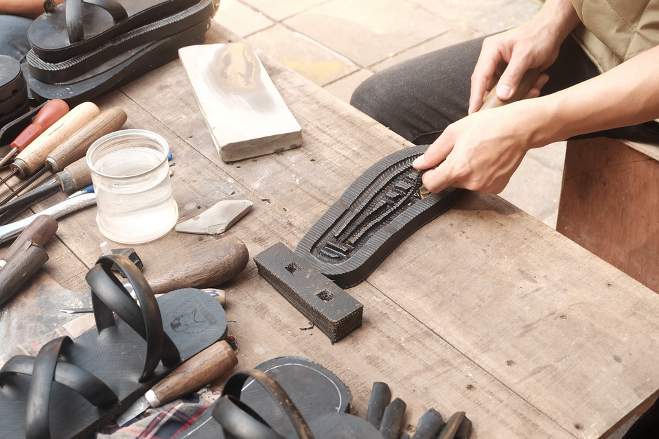 Cận cảnh quy trình làm dép lốp cao su. (Ảnh: Phương Anh/Vietnam+)