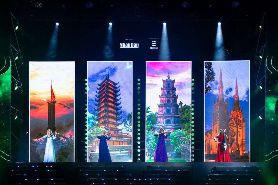 Các nghệ sỹ biểu diễn trong tà áo dài truyền thống biểu diễn trên nền các hình ảnh đậm chất văn hóa-du lịch Việt Nam. (Ảnh: CTV/Vietnam+)