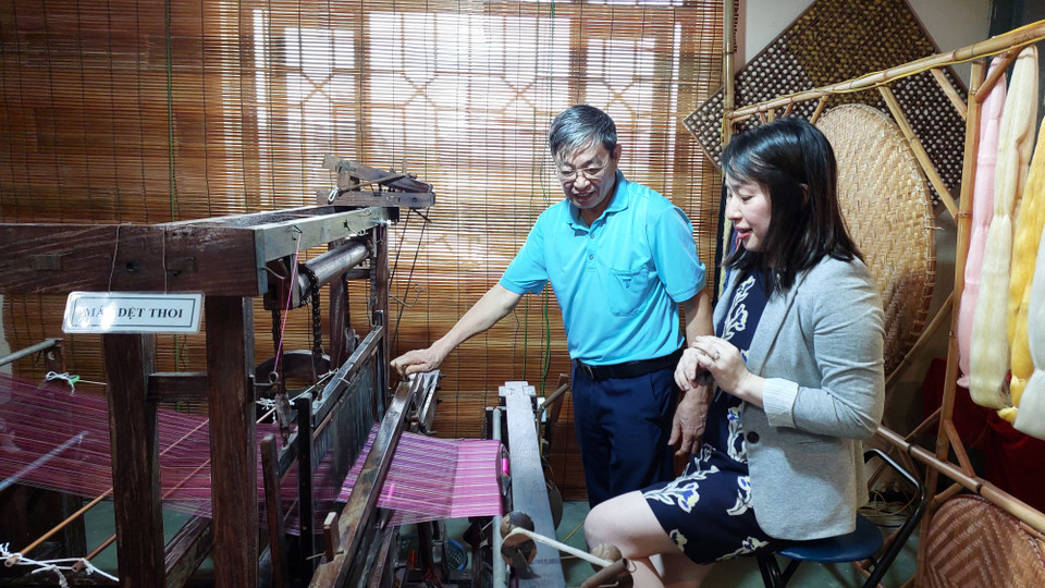 Nghệ nhân tại Trung tâm Nghiên cứu Dâu tằm tơ Trung ương hướng dẫn khách tham quan sử dụng máy dệt thoi. (Ảnh: Minh Thu/Vietnam+)