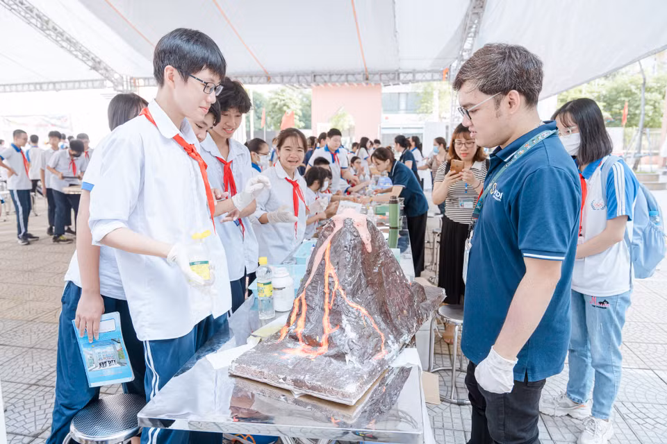 Các em cũng rất hào hứng với thí nghiệm về núi lửa phun trào. (Ảnh: PV/Vietnam+)