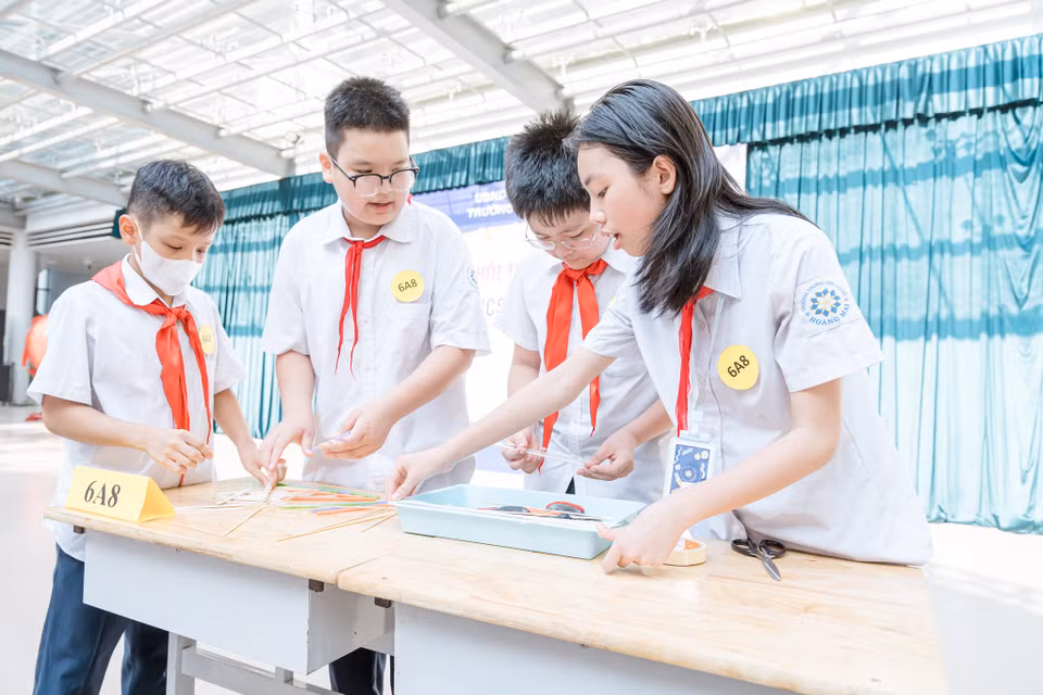 Cả nhóm cùng trao đổi, tính toán để thiết kế và chế tạo cây cầu đặc biệt. (Ảnh: PV/Vietnam+)