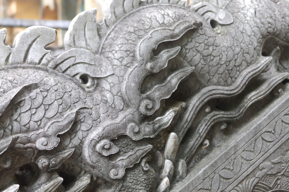 Nếu như rồng thời Lý mang sự nhẹ nhàng, mỏng manh, giống như đang uốn lượn trong mây, rồng thời Trần thể hiện sự mạnh mẽ với thân hình to lớn, khoẻ khoắn thì rồng trong hệ thống bộ thành bậc điện Kính Thiên phía Bắc thời Lê Trung Hưng lại được cách điệu hoa văn tinh xảo với dáng dấp cứng rắn. (Ảnh: PV/Vietnam+)