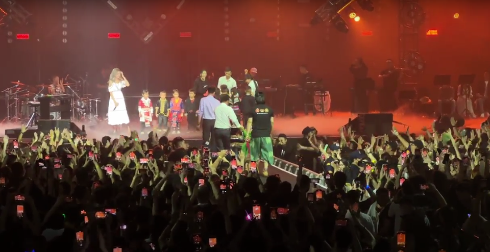 Mặc những bộ trang phục truyền thống, đem theo món quà là những trái pao - biểu tượng của sự trao đi hạnh phúc, may mắn, các em nhỏ khiến khán giả mỉm cười vì sự hồn nhiên, đáng yêu. Trong chuyến đi lên bản thăm các em và thầy cô, biết được nhiều người chưa từng ra khỏi Điện Biên, nên Đen đã rủ mọi người đến xem show nhân dịp này xuống Hà Nội chơi. (Ảnh: CTV/Vietnam+) 