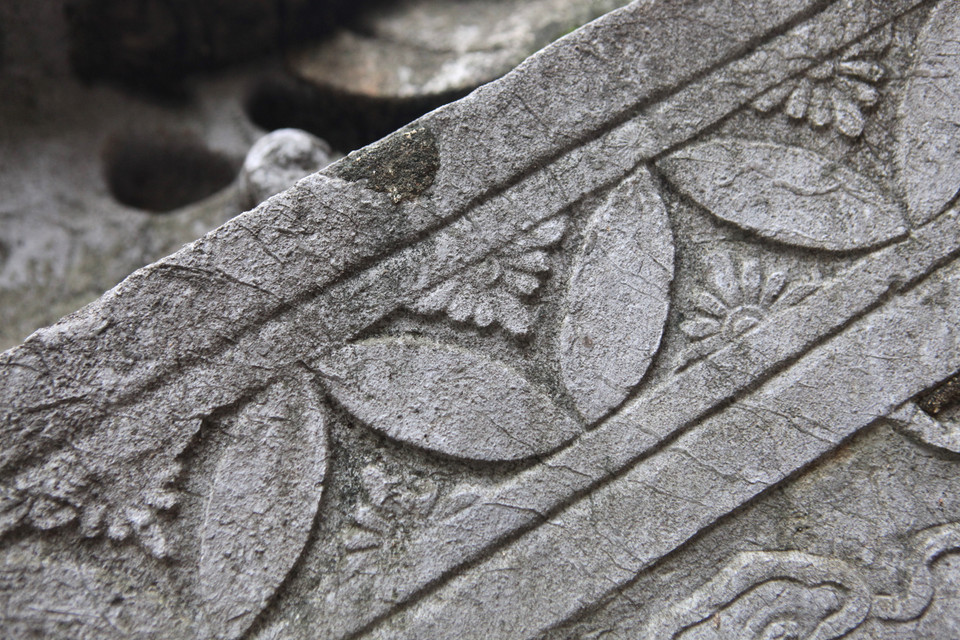 Mặt ngoài lan can hình tam giác có đường diềm chạm một nửa hình hoa liên tiền nối tiếp nhau, góc tạo bởi hai đầu cánh hoa chạm một nửa hình hoa cúc. (Ảnh: PV/Vietnam+) 