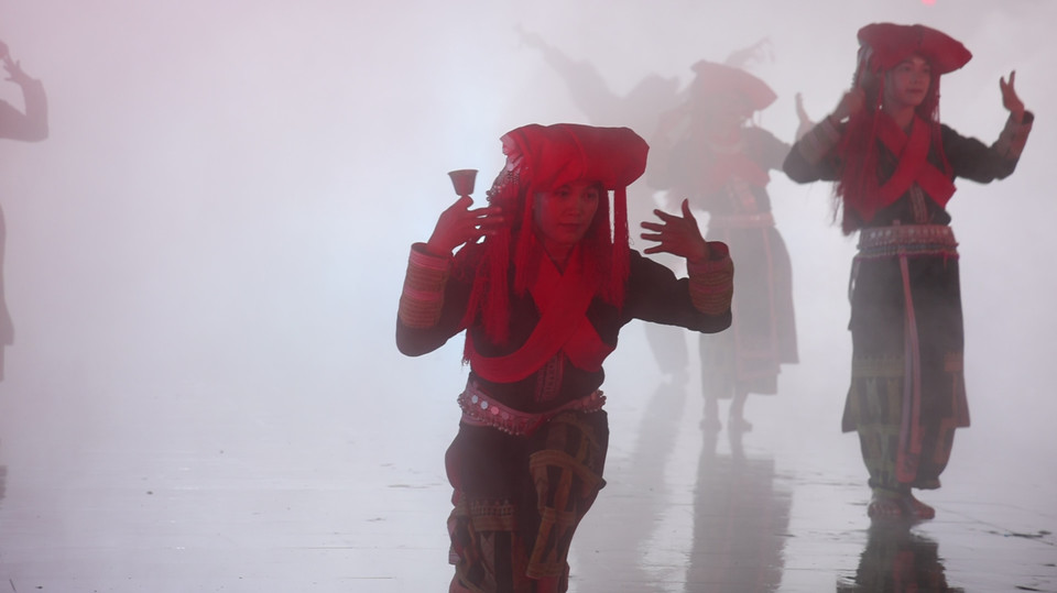 Các nghệ sỹ múa sẽ tái hiện điệu nhảy “Vạn Phù” của thầy cúng người Dao. Các cô gái trong trang phục cô dâu truyền thống cho thấy vẻ đẹp tâm hồn, nhẹ nhàng, e lệ. Chính qua những điệu múa và thanh âm đặc trưng (gồm tiếng tù và, kèn Pí lè và trống, chuông), người Dao Đỏ thể hiện tinh thần lạc quan của mình. (Ảnh: Minh Anh/Vietnam+)