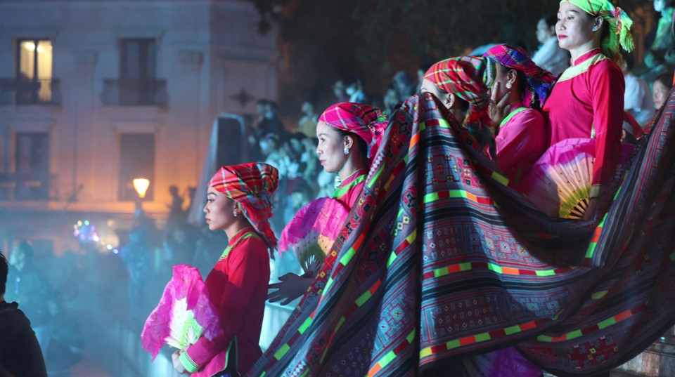 Trái với tông màu trầm đen, tràm, thì trang phục của những cô gái Giáy thường có sắc nổi bật như hồng, xanh, cam… khăn đội đầu cũng khá sáng màu. (Ảnh: Minh Anh/Vietnam+)