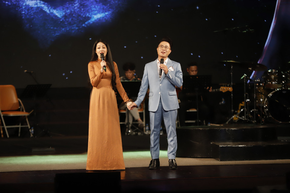 Hai MC Lê Anh-Hồng Nhung cùng trình bày bài thơ 'Bài hát ấy vẫn còn là dang dở,' như chính câu chuyện về sự ra đi đầy tiếc nuối của đôi vợ chồng tài hoa của nền nghệ thuật nước nhà. (Ảnh: PV/Vietnam+)