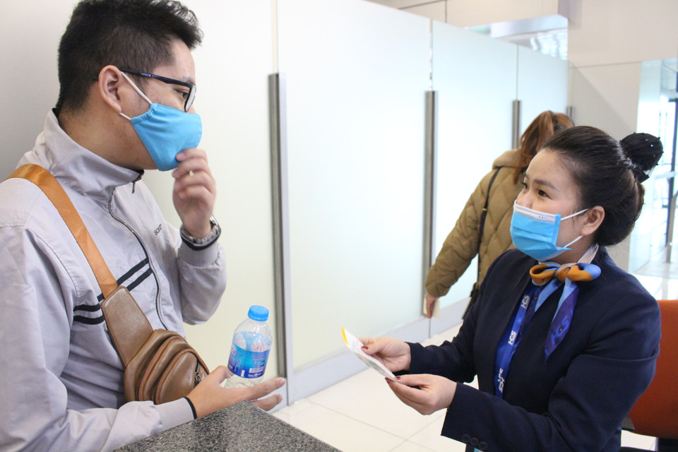 Nhân viên mặt đất kiểm tra vé của hàng khách trước khi lên máy bay. (Ảnh: Minh Anh/Vietnam+)